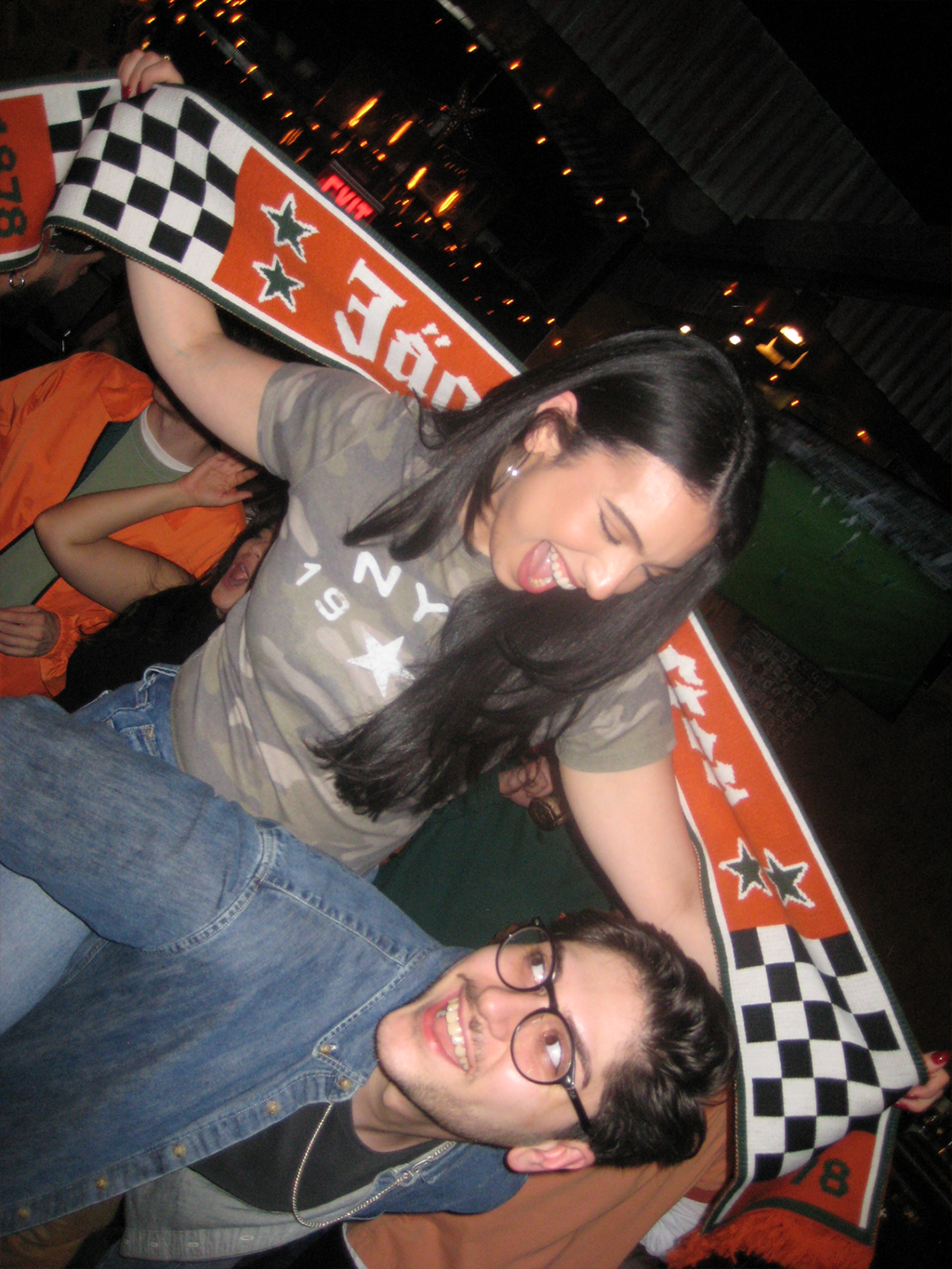 Két ember pózol egy nagy Jägermeister Racing sállal