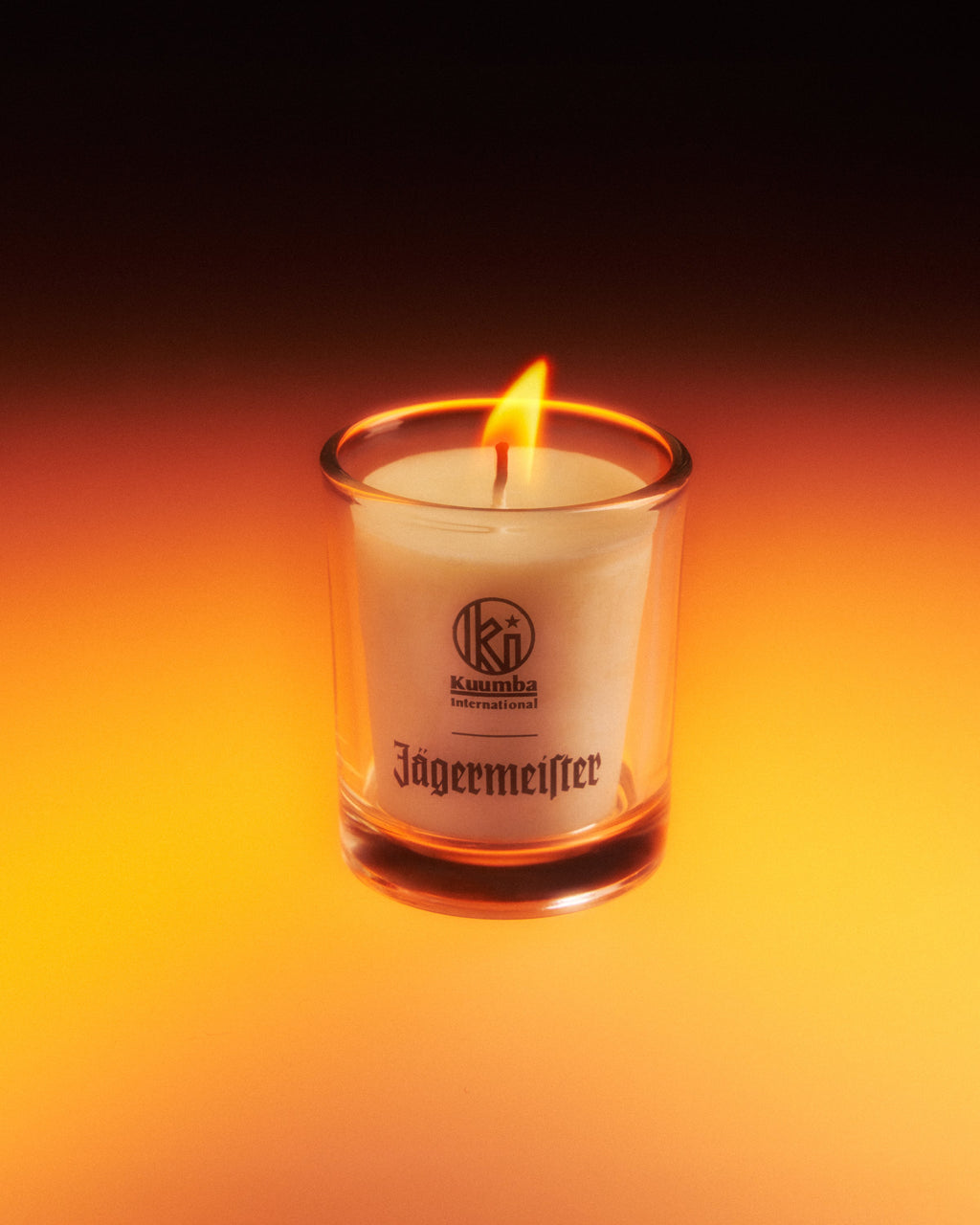 Jagermeister gyertya üvegedényben, sötét háttérrel