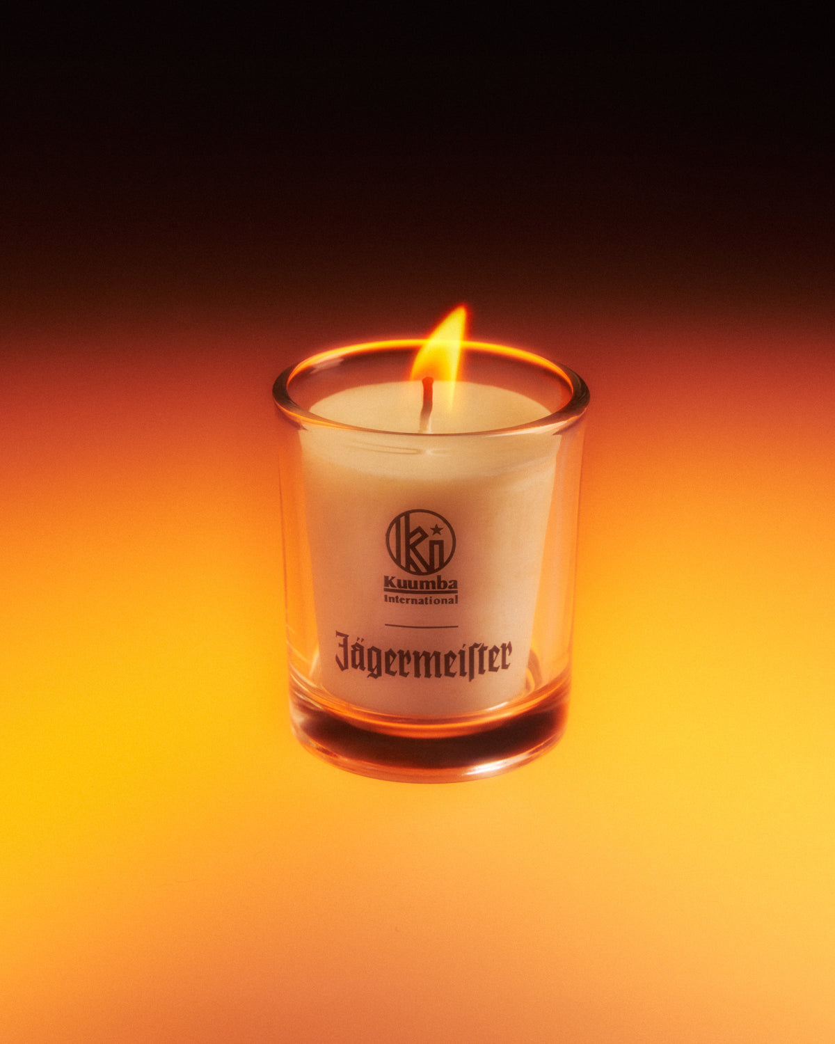 Jagermeister gyertya üvegedényben, sötét háttérrel