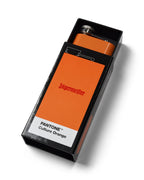 Narancssárga Jägermeister laposüveg egy fekete dobozban, „PANTONE Culture Orange” címkével, fehér háttéren