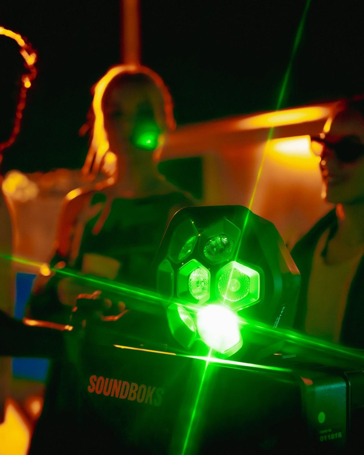 Zölden ragyogó LIghtboks egy Soundboksra helyezve, körülötte bulizó emberekkel