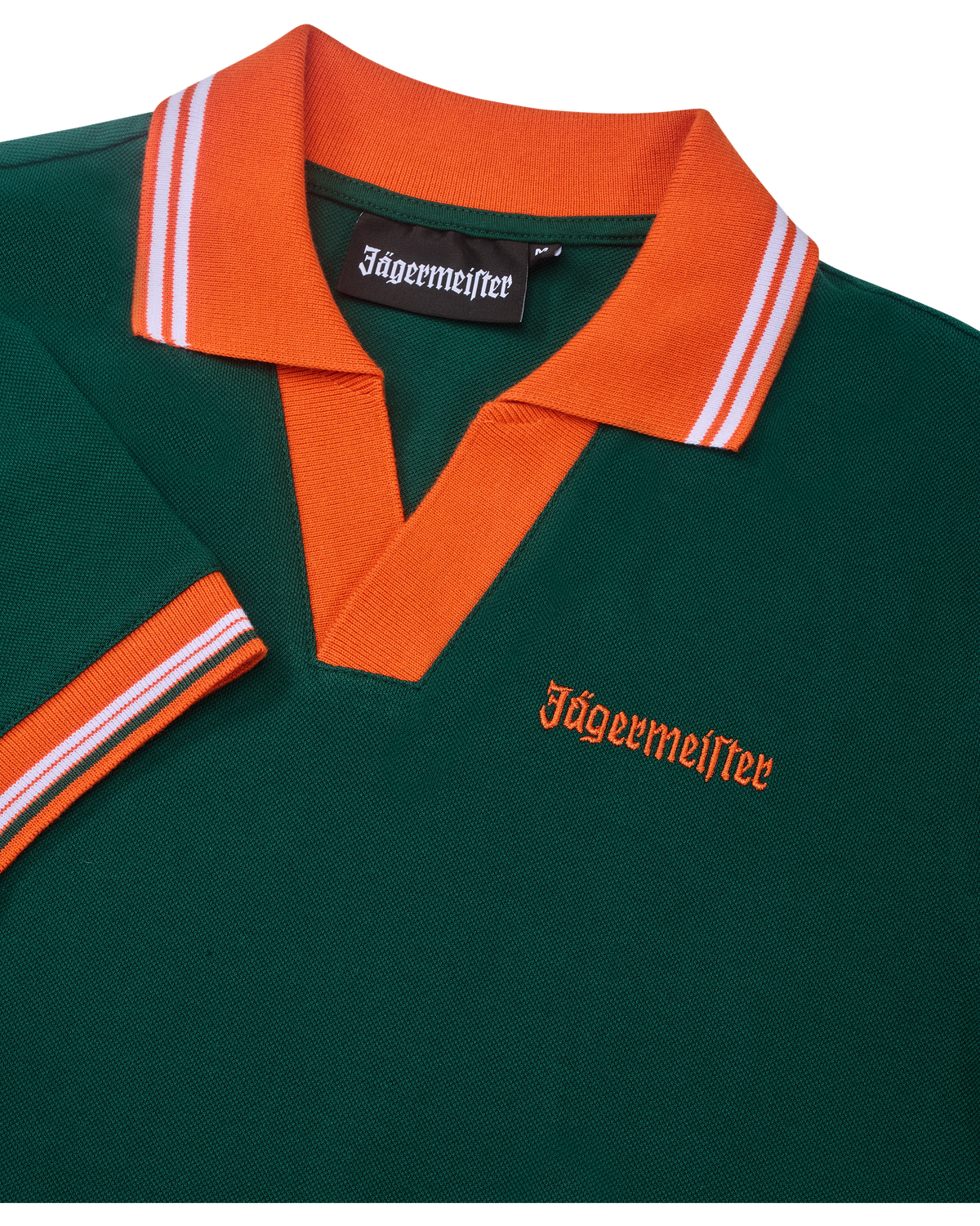 Zöld pólóruha narancssárga gallérral és szegéllyel, Jägermeister-márkajelzéssel.