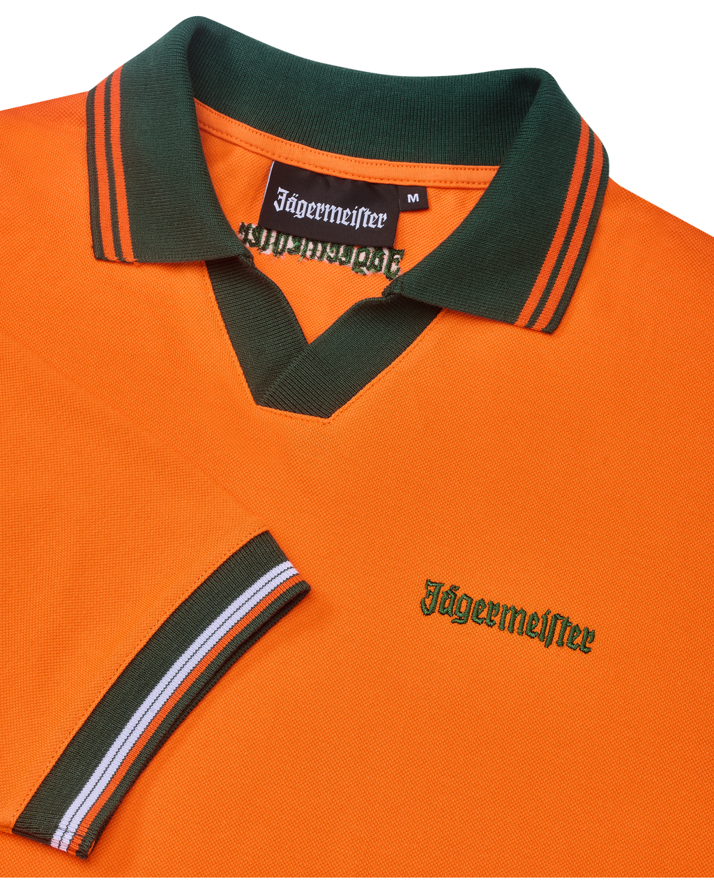 Narancssárga Jägermeister póló zöld gallérral és narancssárga szegéllyel, zöld Jägermeister-márkajelzéssel.