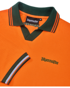 Narancssárga Jägermeister póló zöld gallérral és narancssárga szegéllyel, zöld Jägermeister-márkajelzéssel.