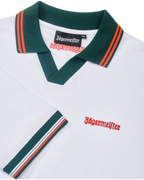 Fehér Jägermeister póló zöld gallérral és narancssárga szegéllyel, narancssárga Jägermeister-márkajelzéssel.