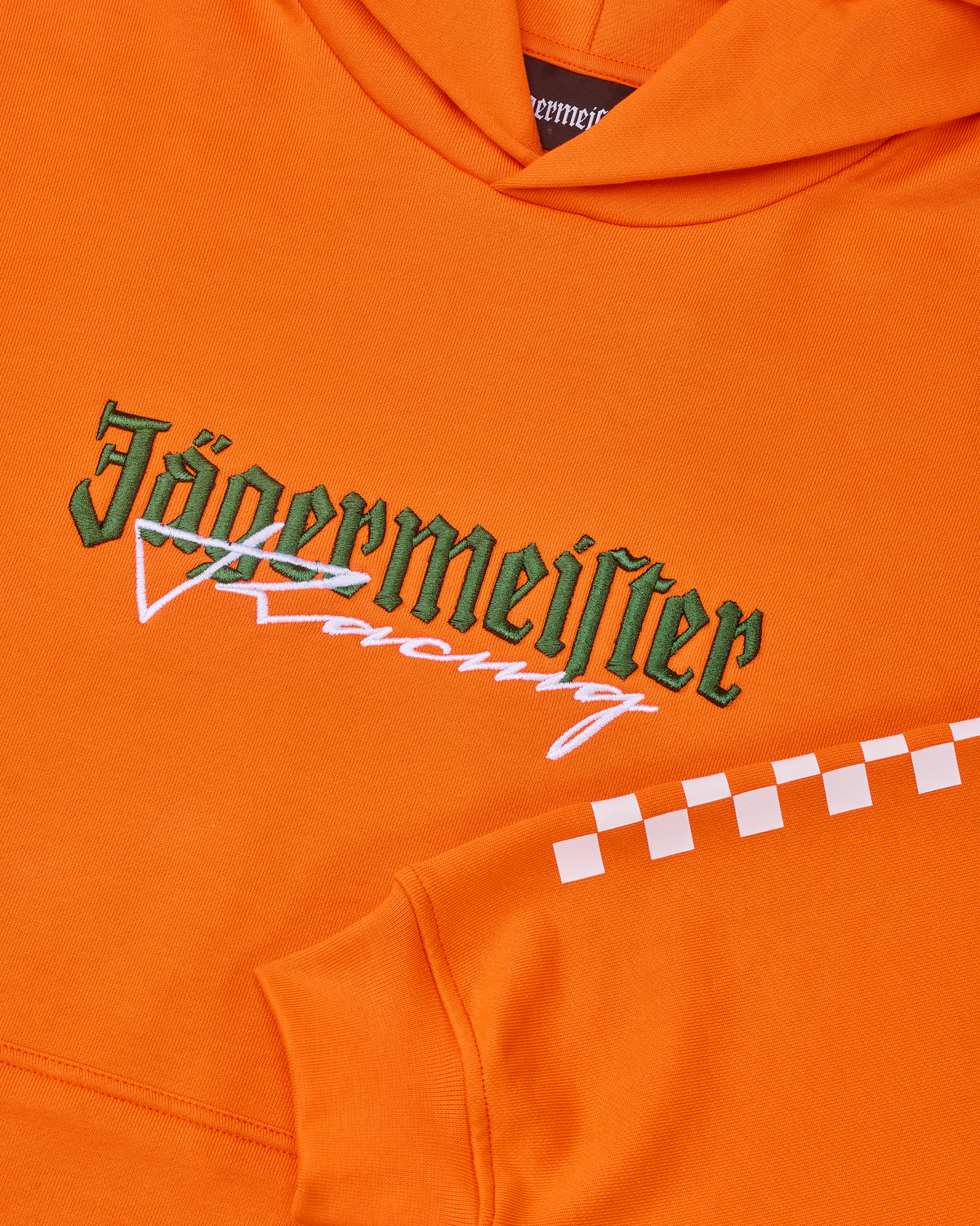 Narancssárga kapucnis pulóver fehér és zöld Jägermeister Racing logóval.