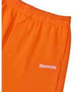 Close-up of orange pants with white Jägermeister logo.