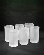 Set of six white Jägermeister shot glasses on a black background