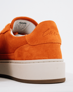 Narancssárga Jägermeister tornacipő hátsó-kisoldalnézete, vastag törtfehér platformtalppal és barna külső talppal; a sarokfülön a hímzett „Curt” név látható.