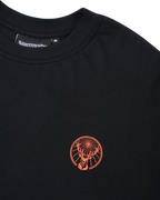 Fekete póló narancssárga Jägermeister logóval.